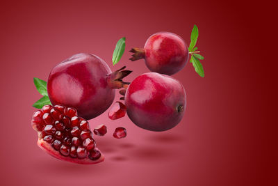 Ripe pomegranate fruit on red background.