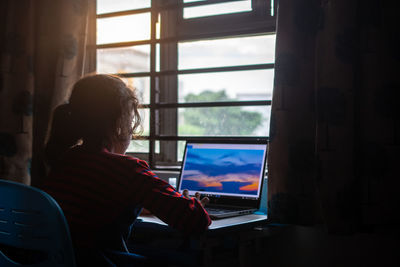 Rear view of man sitting at home