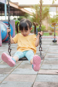 Girl sitting on swing at playground