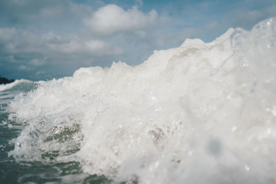 Close-up of water splashing in sea against sky