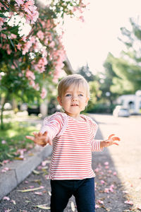 Full length of cute boy standing against plants