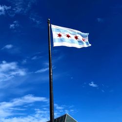 Low angle view of flag against blue sky