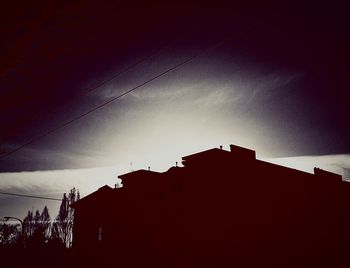 Low angle view of silhouette buildings against sky at sunset