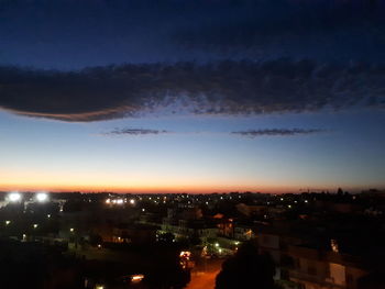 Illuminated cityscape against sky at night