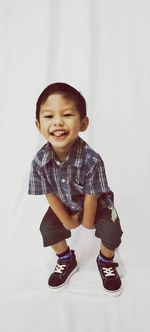 Portrait of smiling boy against white background