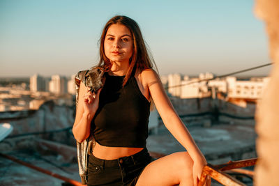 Portrait of young woman on terrace during sunset