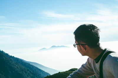 Close-up of young man on mountain against sky