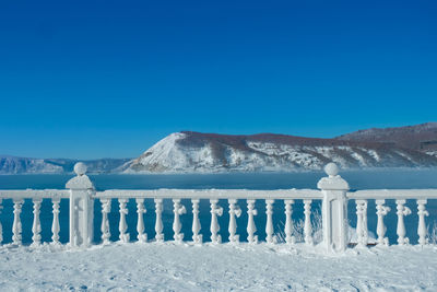 Scenic view of snowcapped mountains against clear blue sky