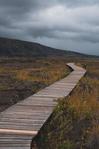 Boardwalk leading towards mountains against sky at volcano national park in hawaii.