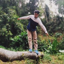 Full length of young man climbing on tree