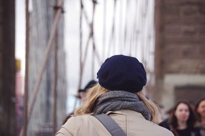 Rear view of woman standing against wall in winter