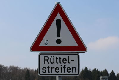 Low angle view of road sign against clear sky