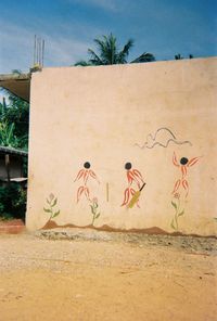 Graffiti on palm tree against sky