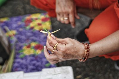 Midsection of woman holding flower petals on floor