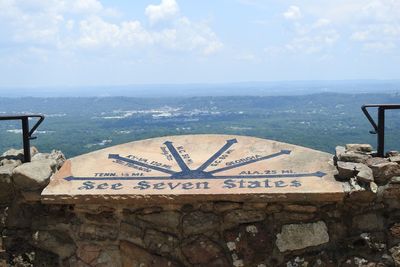 Information sign by sea against sky