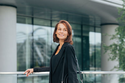 Portrait of young woman standing in city