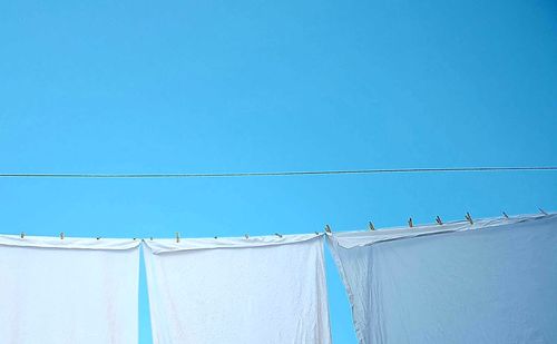 Low angle view of sea against clear blue sky