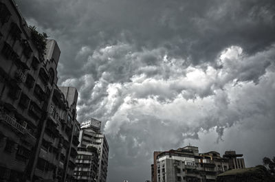 Low angle view of cloudy sky over buildings in city