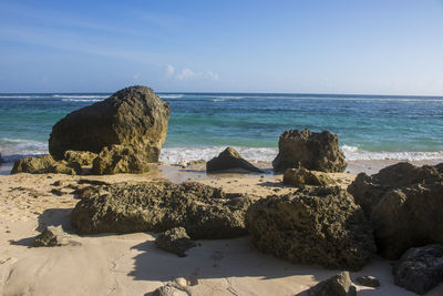 Scenic view of rocks on beach against sky