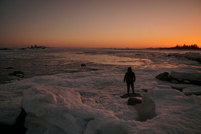 Silhouette man walking on snow