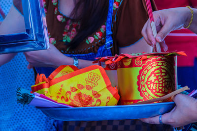 Midsection of woman holding multi colored candies