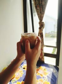 Midsection of man drinking coffee in glass window