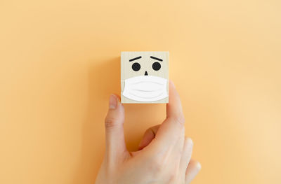 Close-up of woman holding hands against white background