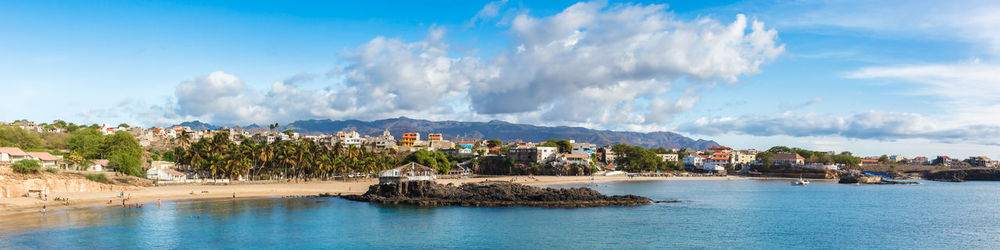 Panoramic view of sea and buildings against sky