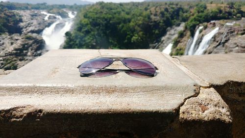 Close-up of sunglasses on sand at beach against sky