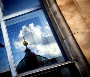 Low angle view of glass building against sky