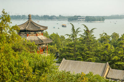 Historical chinese building by lake against sky