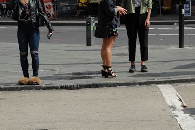 Low section of women walking on road