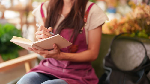 Midsection of woman reading book
