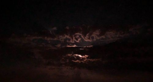 Low angle view of illuminated moon in sky at night