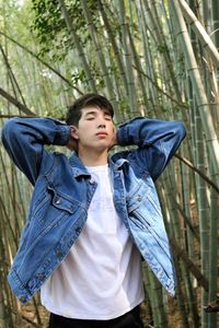 Portrait of young man standing in forest