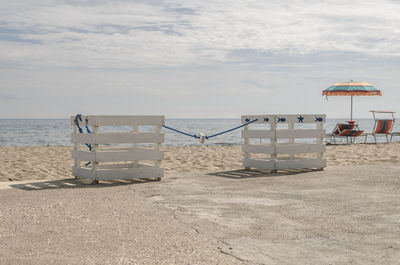 Lifeguard hut on beach against sky