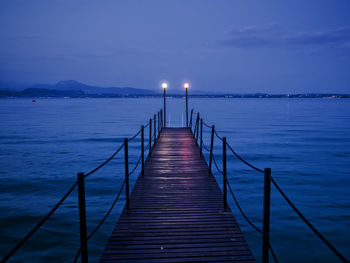 Pier over sea against sky at dusk