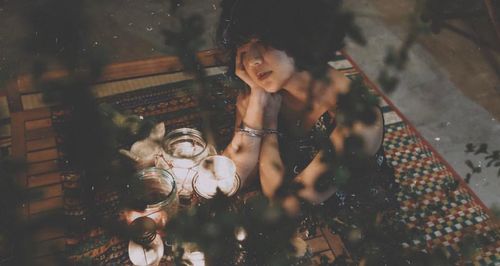 High angle portrait of woman holding camera reflection