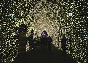 Low angle view of people walking in illuminated building