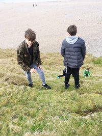 Full length of friends standing on field