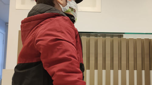 Side view of woman standing against wall