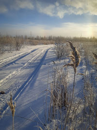 Scenic view of snow covered field against sky