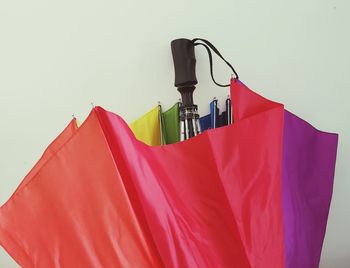 Close-up of multi colored flags hanging against white background