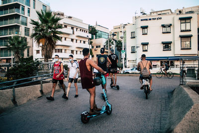 People on street against buildings in city