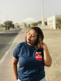 Portrait of young woman standing on street