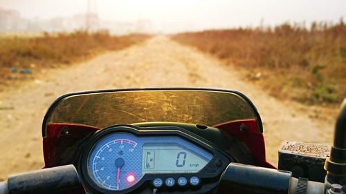 Cropped image of motorcycle on dirt road