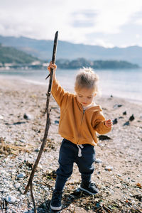 Rear view of boy standing at beach