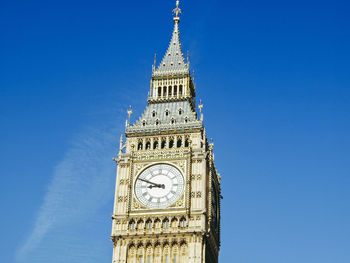 Low angle view of clock tower against blue sky