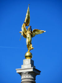 Low angle view of statue against blue sky