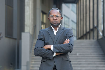 Portrait of young man standing against building